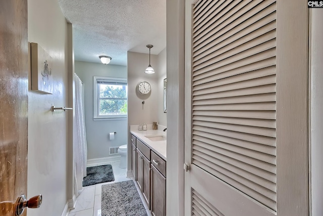 full bathroom with toilet, a textured ceiling, vanity, baseboards, and a shower with curtain