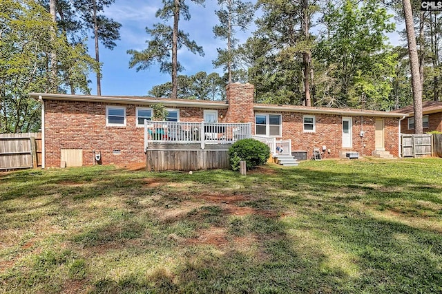 rear view of house with brick siding, a wooden deck, and a chimney