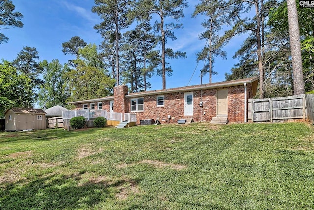 rear view of house featuring entry steps, a storage shed, brick siding, a chimney, and an outdoor structure