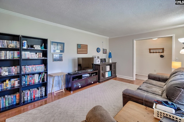 living area with crown molding, wood finished floors, a textured ceiling, and baseboards