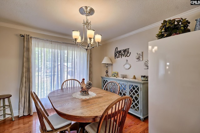 dining area with wood finished floors, crown molding, a chandelier, and a textured ceiling