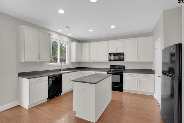 kitchen featuring black appliances, a sink, dark countertops, white cabinetry, and recessed lighting