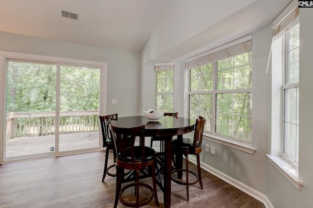 dining area with wood finished floors, baseboards, and vaulted ceiling