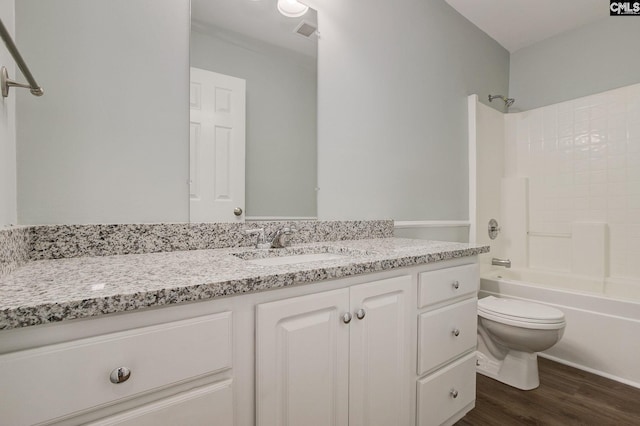 bathroom featuring wood finished floors, vanity, toilet, and bathtub / shower combination