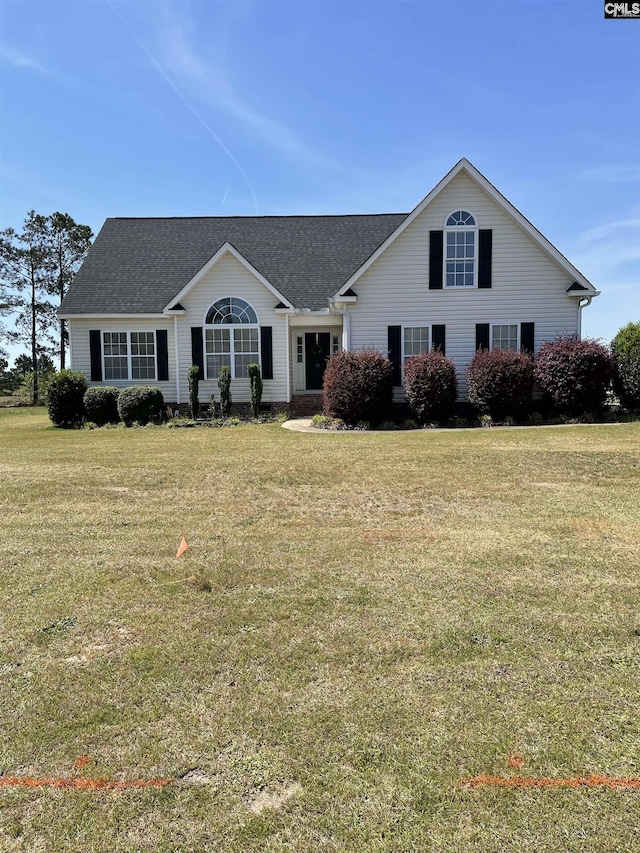 view of front of property with a front yard and roof with shingles