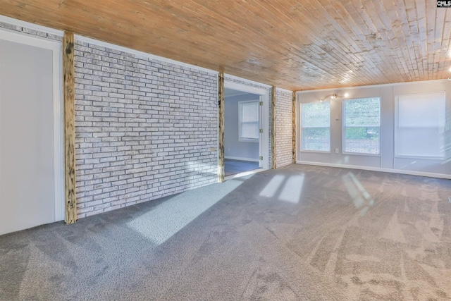 spare room featuring brick wall, wooden ceiling, and carpet floors