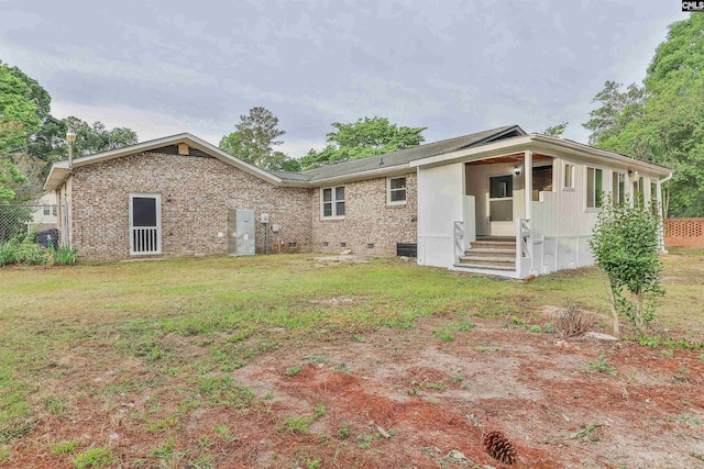 back of house featuring brick siding and crawl space