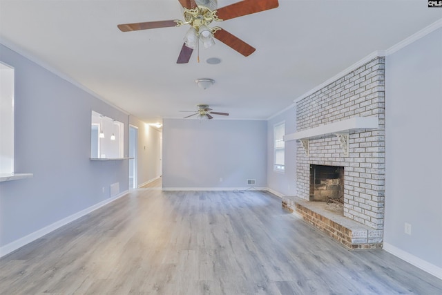 unfurnished living room with a ceiling fan, a brick fireplace, wood finished floors, ornamental molding, and baseboards