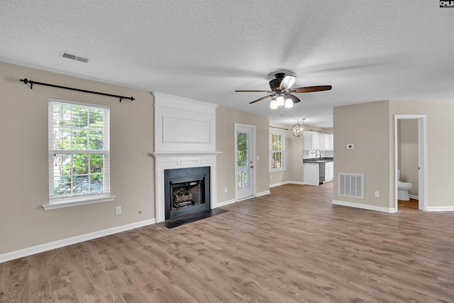 103 Beacon Ln, Columbia, SC 29229 - unfurnished living room with a ceiling fan, light wood-style flooring, a fireplace, a textured ceiling, and baseboards
