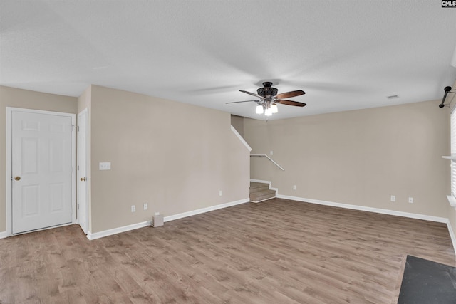 103 Beacon Ln, Columbia, SC 29229 - unfurnished living room featuring ceiling fan, wood finished floors, stairs, baseboards, and a textured ceiling