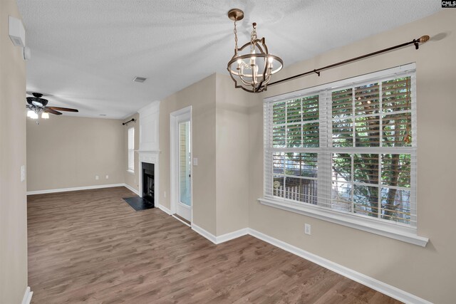 103 Beacon Ln, Columbia, SC 29229 - unfurnished living room with a chandelier, a textured ceiling, wood finished floors, baseboards, and ceiling fan