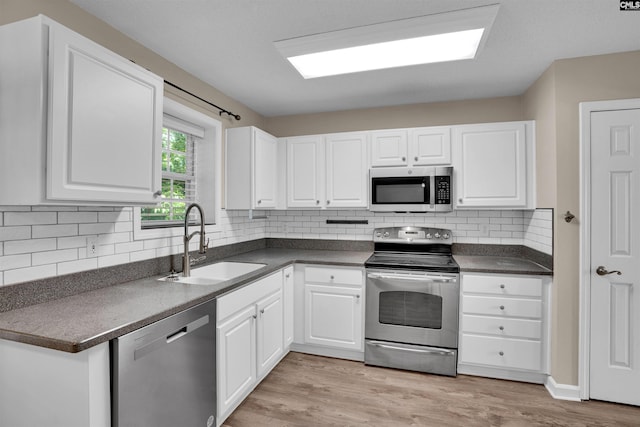 103 Beacon Ln, Columbia, SC 29229 - kitchen featuring appliances with stainless steel finishes, a sink, dark countertops, white cabinetry, and tasteful backsplash
