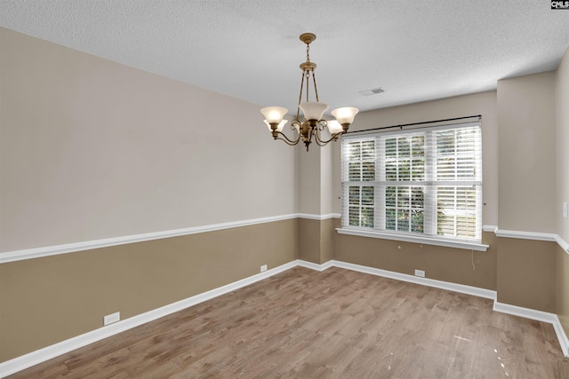 103 Beacon Ln, Columbia, SC 29229 - empty room featuring a chandelier, wood finished floors, baseboards, and a textured ceiling