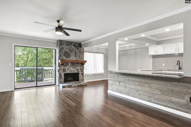 284 Outrigger Ln, Columbia, SC 29212 - unfurnished living room with baseboards, ceiling fan, dark wood-style floors, crown molding, and a stone fireplace