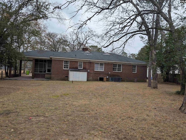 6427 Briarwood Rd, Columbia, SC 29206 - rear view of property featuring a sunroom, cooling unit, brick siding, and a yard