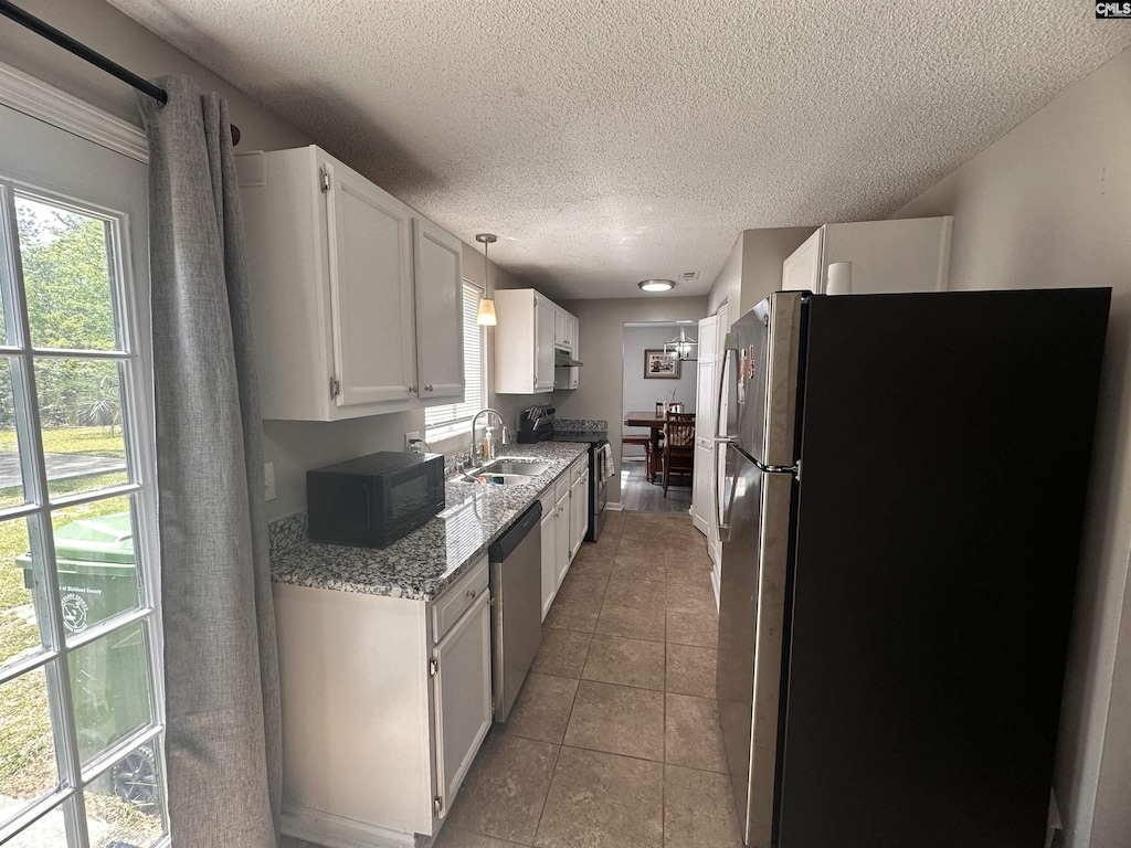 404 N Donar Dr, Columbia, SC 29229 - kitchen featuring stainless steel appliances, a textured ceiling, plenty of natural light, white cabinetry, and light stone countertops