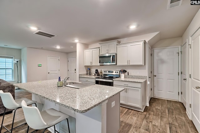 2040 Elmridge Rd, Columbia, SC 29209 - kitchen with stainless steel appliances, a breakfast bar, light wood finished floors, a sink, and light stone countertops