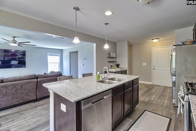 171 Turnfield Dr, West Columbia, SC 29170 - kitchen with stainless steel appliances, a sink, dark brown cabinetry, open floor plan, and an island with sink