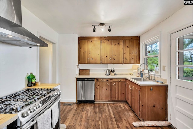 1217 Jensen St, West Columbia, SC 29169 - kitchen featuring stainless steel appliances, wall chimney exhaust hood, a sink, dark wood-style flooring, and light countertops