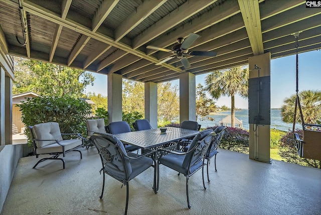 view of patio featuring a water view, outdoor dining area, and a ceiling fan