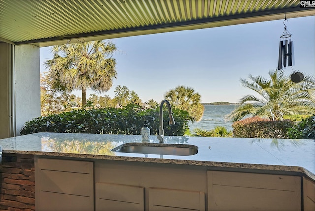 view of patio featuring a sink, a water view, and area for grilling