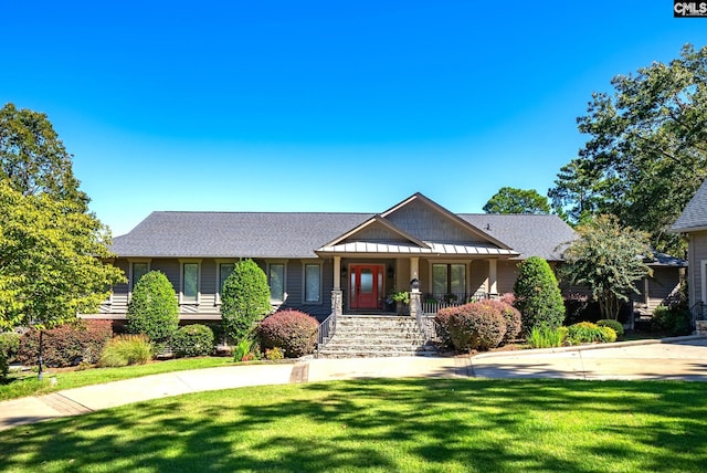 craftsman-style house featuring a front yard, a porch, and a shingled roof