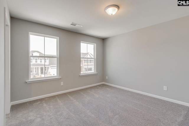 carpeted empty room featuring baseboards