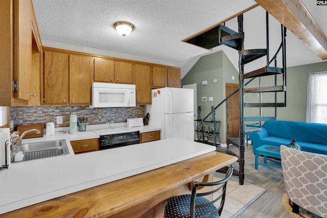 kitchen with white appliances, a sink, light countertops, a peninsula, and backsplash