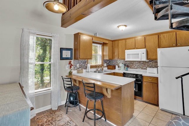 kitchen with white appliances, a sink, light countertops, and tasteful backsplash