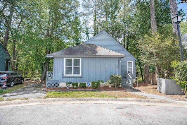 view of front of house featuring fence and roof with shingles