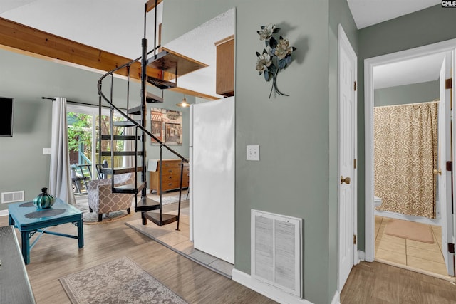 hall with wood finished floors, baseboards, and stairway