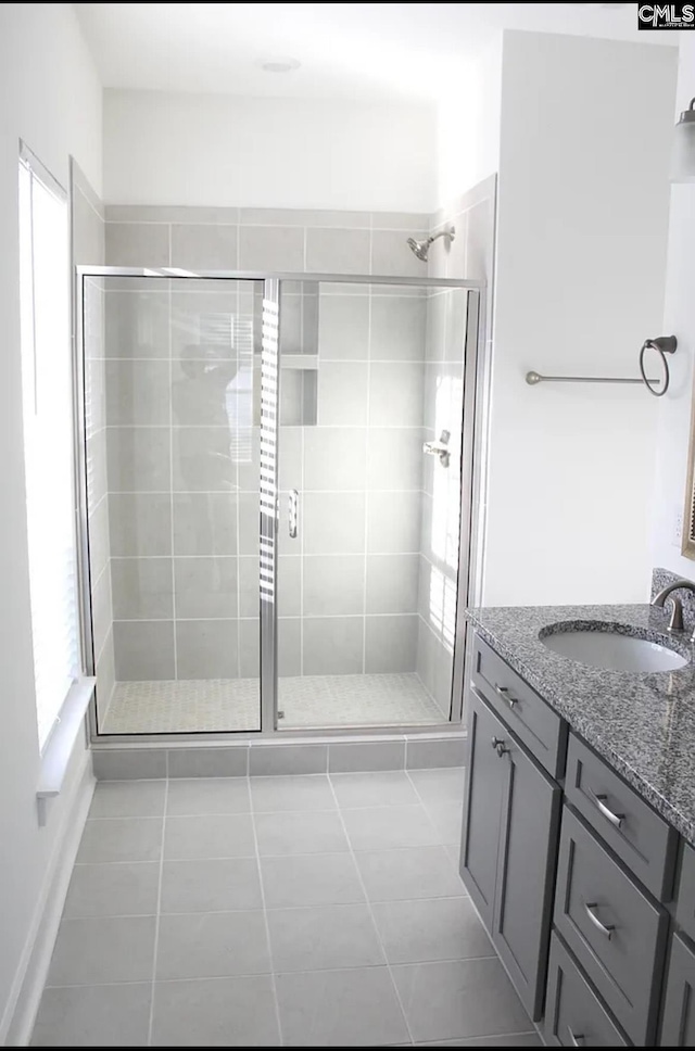 full bathroom featuring tile patterned flooring, a shower stall, and vanity