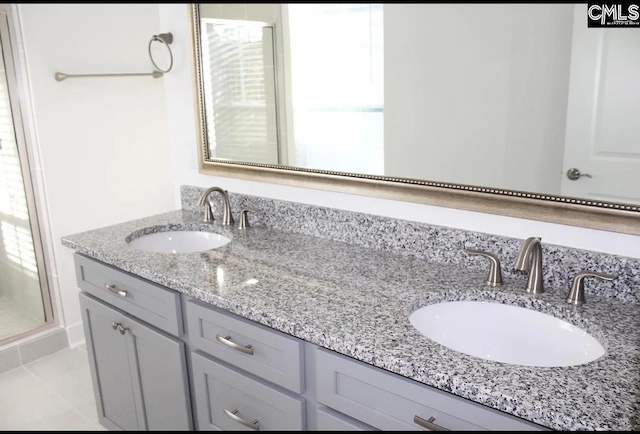 bathroom with double vanity and a stall shower