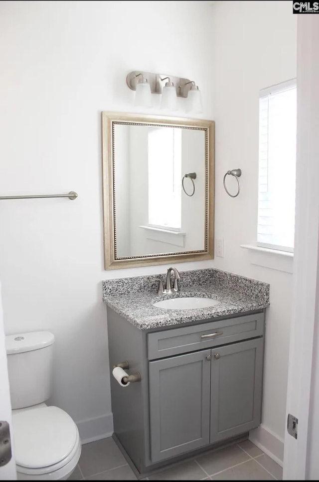 bathroom with healthy amount of natural light, vanity, and baseboards