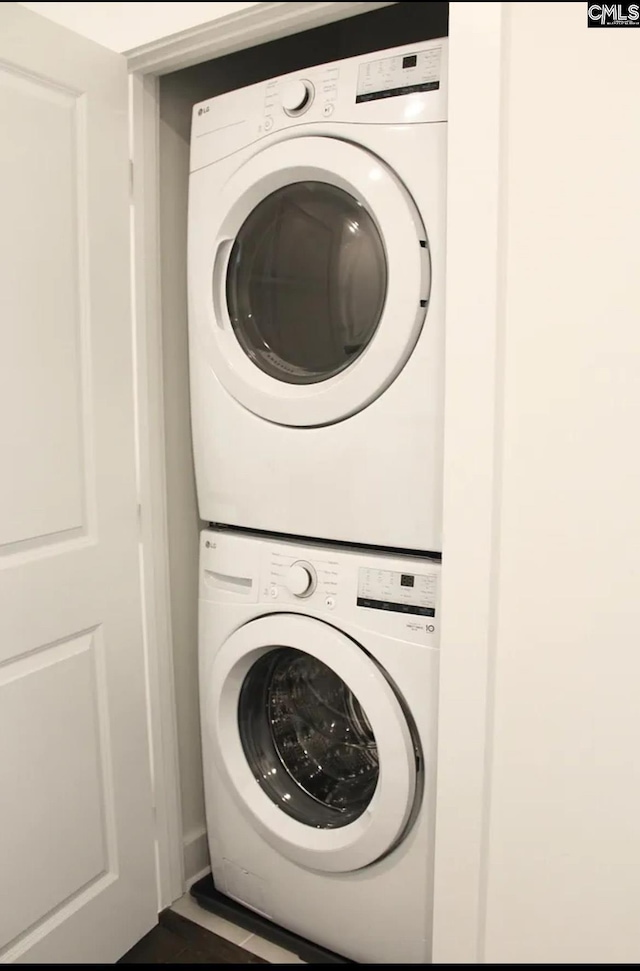 clothes washing area with stacked washer / dryer