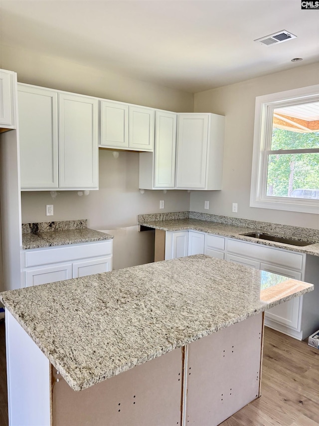281 Osprey Pointe Ln, Prosperity, SC 29127 - kitchen featuring white cabinets, light stone counters, and light wood-type flooring