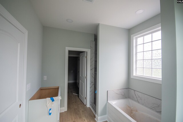 281 Osprey Pointe Ln, Prosperity, SC 29127 - bathroom with healthy amount of natural light, a garden tub, wood finished floors, baseboards, and recessed lighting