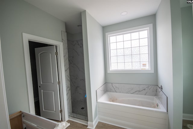 281 Osprey Pointe Ln, Prosperity, SC 29127 - bathroom featuring a garden tub, a marble finish shower, and wood finished floors