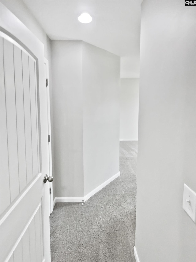 hallway with carpet flooring and baseboards