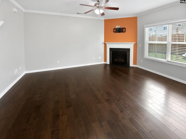 unfurnished living room with ceiling fan, dark wood-style floors, ornamental molding, a fireplace with flush hearth, and baseboards
