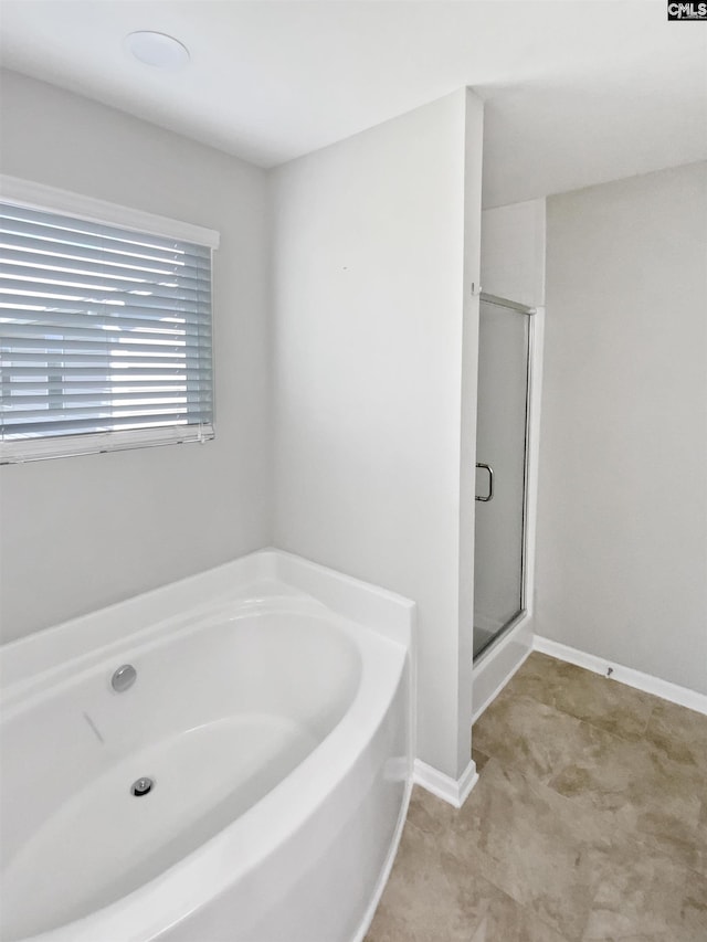bathroom featuring a bath and a shower stall