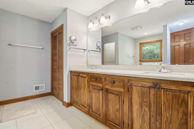 bathroom featuring baseboards, tile patterned flooring, double vanity, and a closet