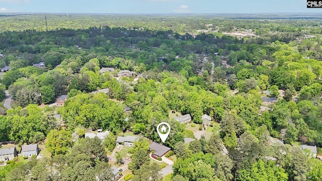 aerial view of property and surrounding area with a heavily wooded area