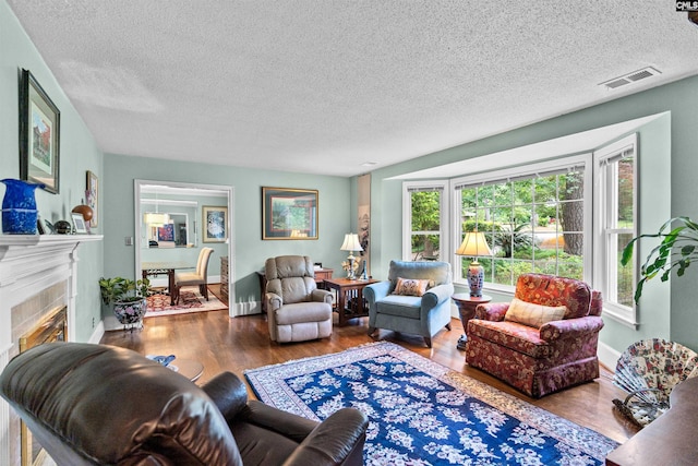 4833 Circle Dr, Columbia, SC 29206 - living area with a tile fireplace, a textured ceiling, wood finished floors, and baseboards