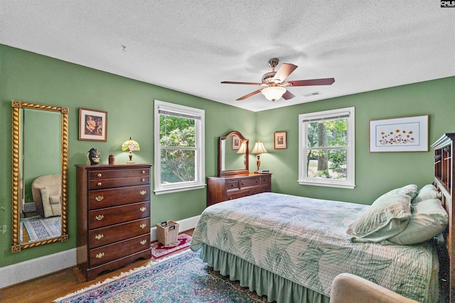 4833 Circle Dr, Columbia, SC 29206 - bedroom with baseboards, multiple windows, wood finished floors, ceiling fan, and a textured ceiling