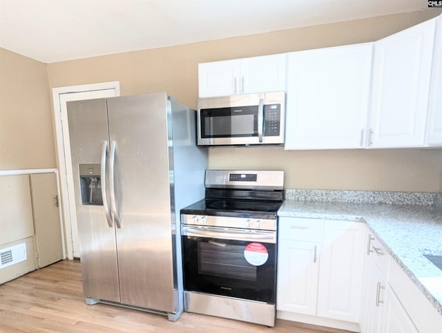 1921 Spotswood Dr, Columbia, SC 29210 - kitchen with appliances with stainless steel finishes, white cabinets, and light wood-style floors