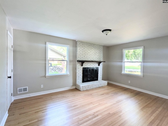 1921 Spotswood Dr, Columbia, SC 29210 - unfurnished living room with light wood-style floors, a brick fireplace, and baseboards