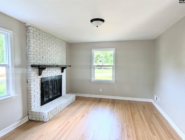 1921 Spotswood Dr, Columbia, SC 29210 - unfurnished living room with plenty of natural light, hardwood / wood-style floors, a brick fireplace, and baseboards