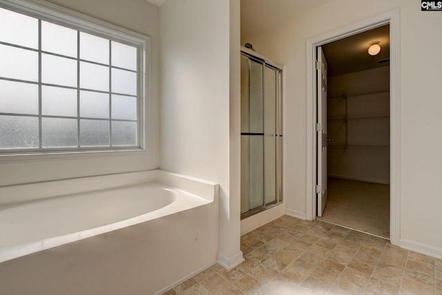 175 Nestle Ct, Columbia, SC 29209 - bathroom featuring baseboards, a shower stall, a bath, a spacious closet, and stone finish flooring