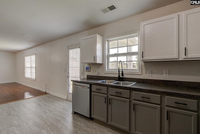 175 Nestle Ct, Columbia, SC 29209 - kitchen featuring stainless steel dishwasher, a sink, dark countertops, and gray cabinetry
